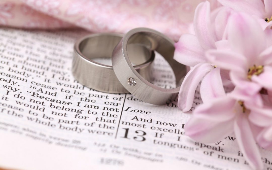Wedding rings on Bible 1st Corinthians 13, a passage about love.